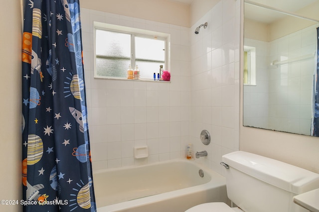 bathroom featuring shower / bath combination with curtain and toilet