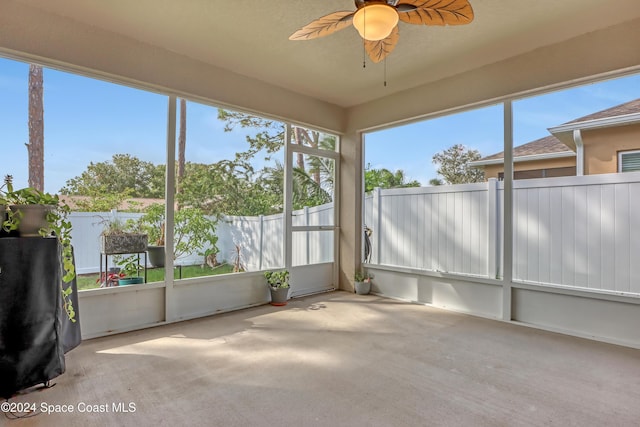 unfurnished sunroom with ceiling fan