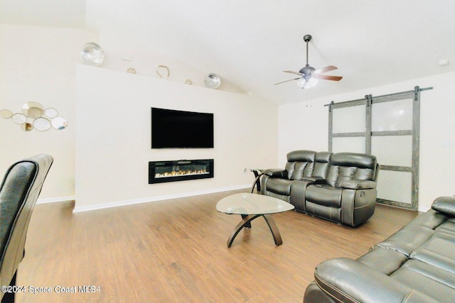 458 Barcelona Rd SE, Palm Bay, FL 32909 - living area with lofted ceiling, wood finished floors, a ceiling fan, a glass covered fireplace, and baseboards