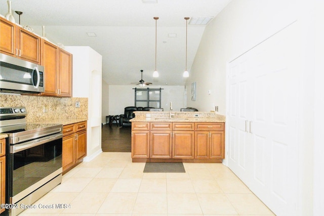 kitchen featuring lofted ceiling, decorative light fixtures, tasteful backsplash, sink, and appliances with stainless steel finishes