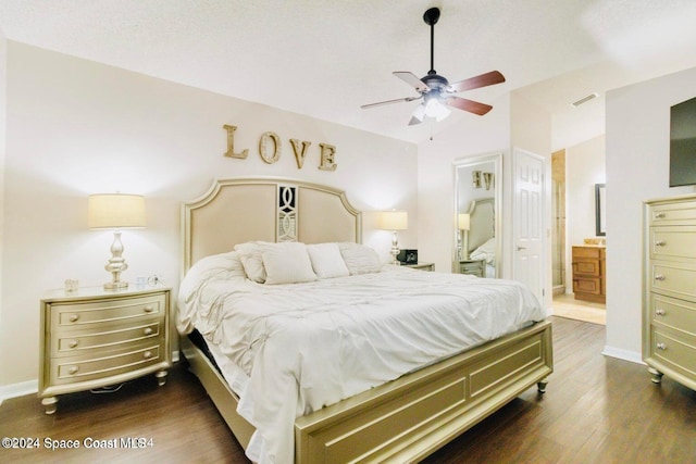 bedroom with vaulted ceiling, ceiling fan, dark hardwood / wood-style flooring, and ensuite bath