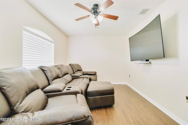 living room featuring ceiling fan, hardwood / wood-style floors, and a textured ceiling