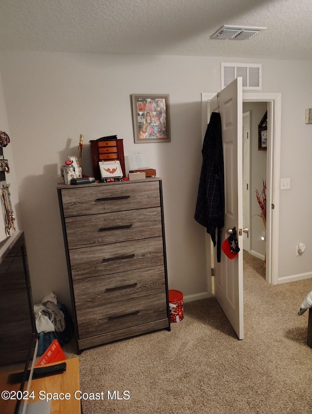 bedroom featuring a textured ceiling and light carpet