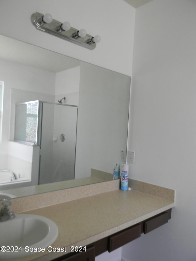 bathroom featuring vanity and a shower with door