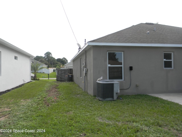 view of property exterior with central air condition unit and a yard