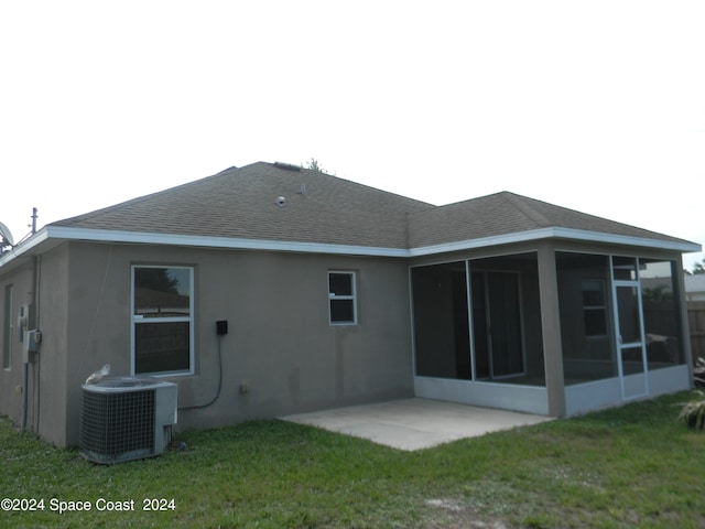 rear view of house with a lawn, a sunroom, a patio, and central AC unit