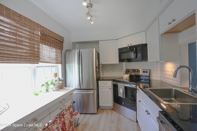 kitchen with appliances with stainless steel finishes, backsplash, white cabinetry, and sink