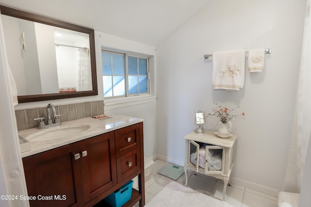 bathroom featuring tile patterned flooring, vanity, walk in shower, and lofted ceiling