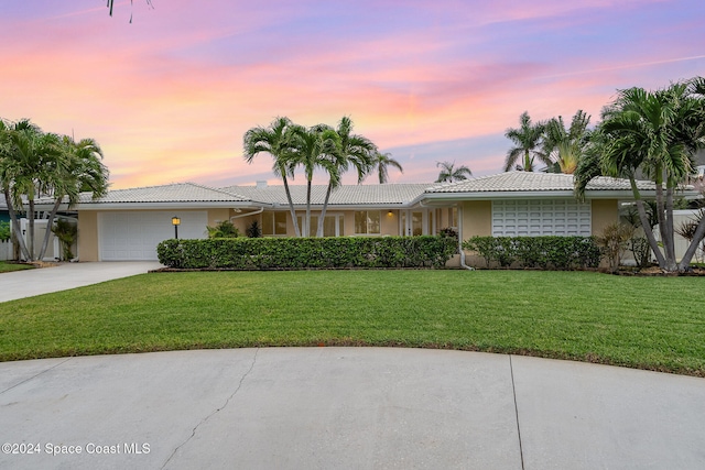 single story home with a lawn and a garage