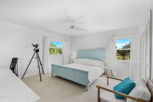 carpeted bedroom featuring ceiling fan and a closet