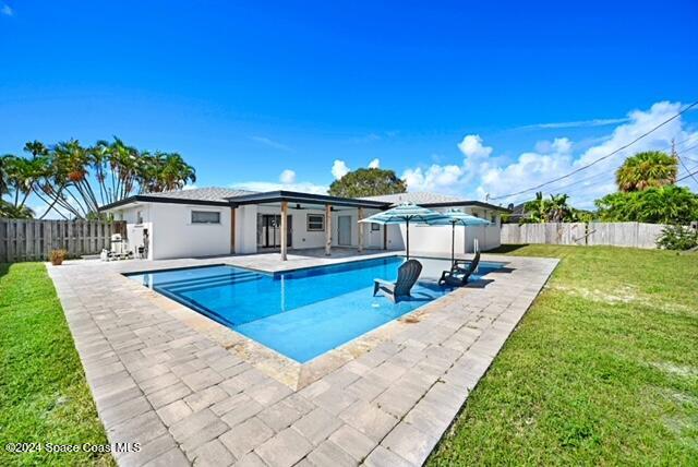 view of swimming pool with a yard and a patio