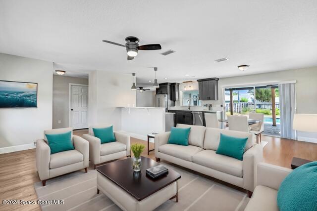 living room featuring light hardwood / wood-style floors and ceiling fan