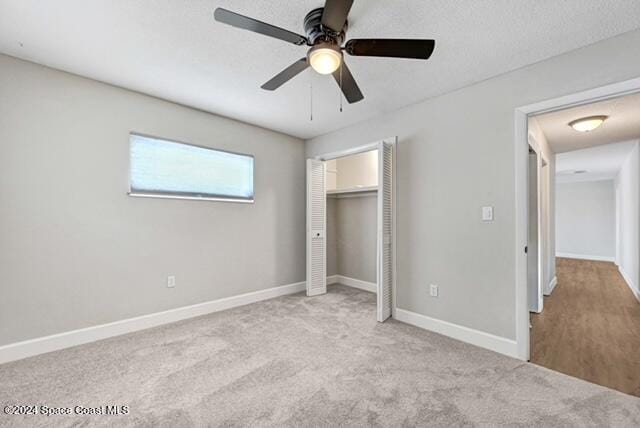 unfurnished bedroom with ceiling fan, a closet, and light colored carpet