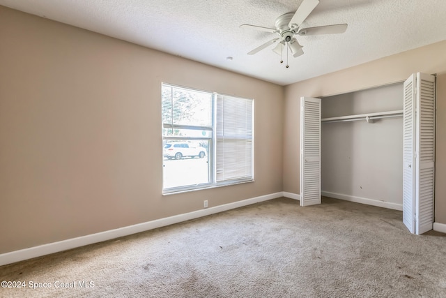 unfurnished bedroom featuring ceiling fan, a closet, carpet, and a textured ceiling