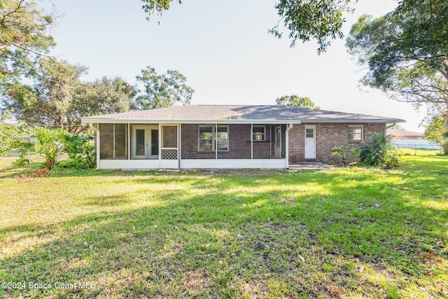 ranch-style home featuring a sunroom and a front lawn