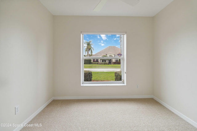 carpeted spare room with ceiling fan