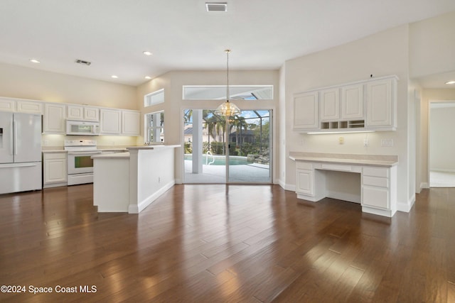 kitchen featuring white cabinets, white appliances, dark hardwood / wood-style floors, and hanging light fixtures