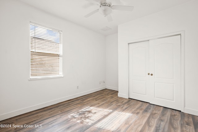 unfurnished bedroom with hardwood / wood-style flooring, ceiling fan, and a closet