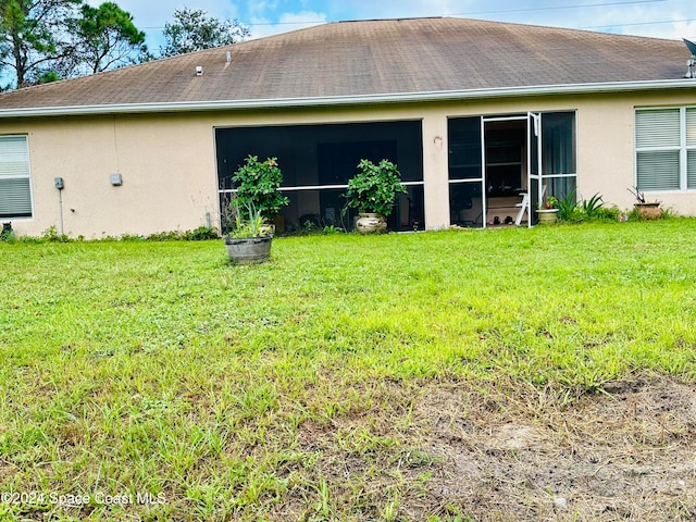 rear view of property with a sunroom and a yard