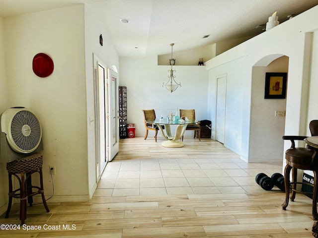 dining space with light hardwood / wood-style floors and lofted ceiling