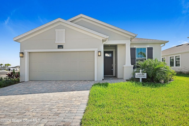 ranch-style home with a garage and a front lawn