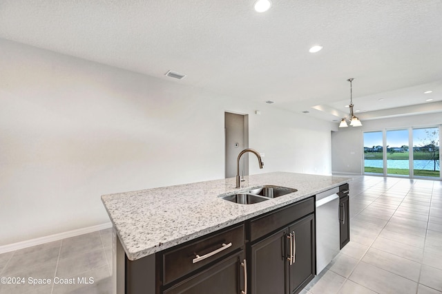 kitchen with a water view, sink, stainless steel dishwasher, an island with sink, and light tile patterned flooring