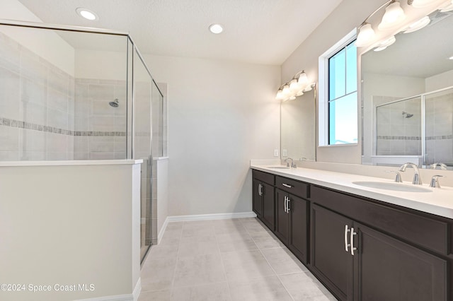 bathroom with tile patterned flooring, vanity, and an enclosed shower