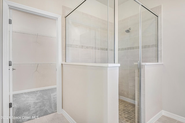 bathroom with tile patterned floors and a shower with door