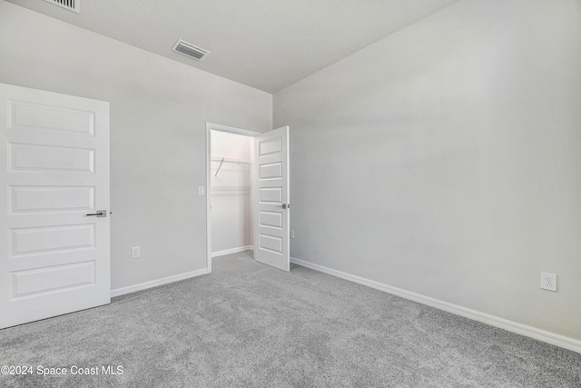 unfurnished bedroom featuring carpet, a spacious closet, and a closet