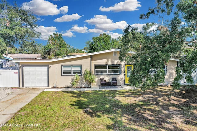 view of front of house featuring a garage, a front yard, and solar panels