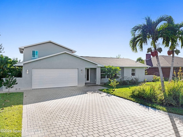 379 Hiawatha Way, Melbourne Beach, FL 32951 - view of front facade with an attached garage, decorative driveway, and stucco siding