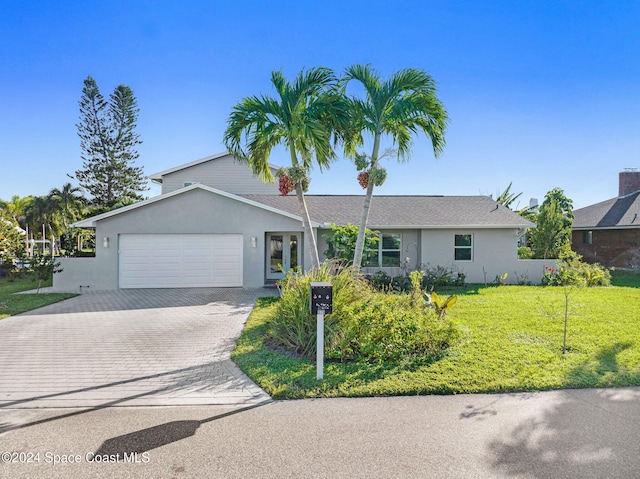 379 Hiawatha Way, Melbourne Beach, FL 32951 - ranch-style house featuring stucco siding, decorative driveway, an attached garage, and a front lawn
