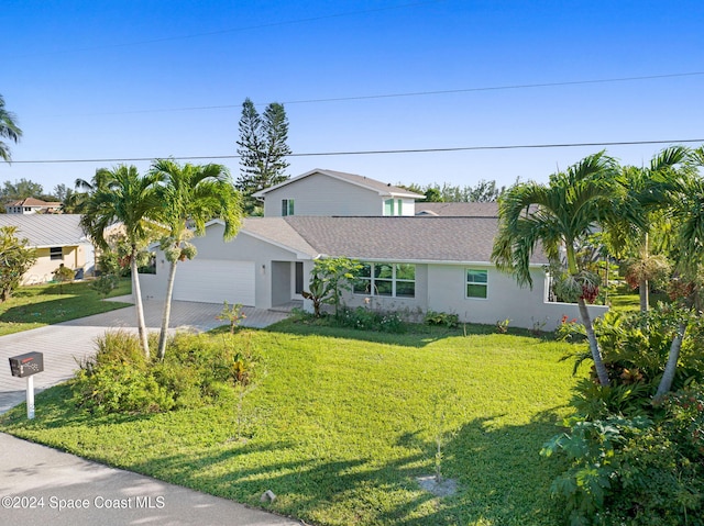 379 Hiawatha Way, Melbourne Beach, FL 32951 - view of front facade with stucco siding, an attached garage, a front yard, and driveway