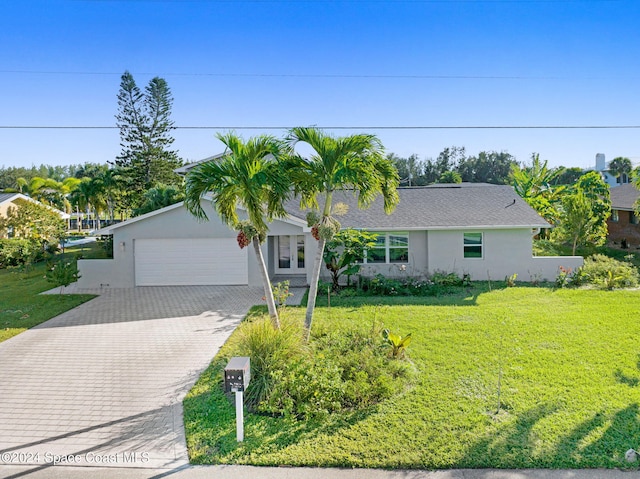 379 Hiawatha Way, Melbourne Beach, FL 32951 - ranch-style home featuring stucco siding, an attached garage, decorative driveway, and a front lawn