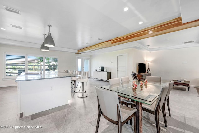 dining area featuring a raised ceiling, sink, french doors, and ornamental molding