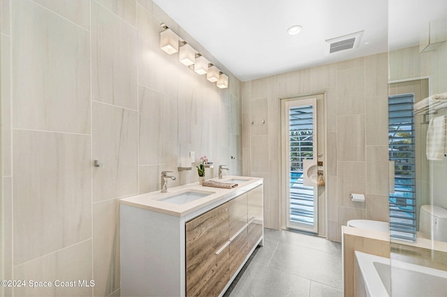 379 Hiawatha Way, Melbourne Beach, FL 32951 - full bath featuring tile walls, a tub to relax in, double vanity, and tile patterned floors