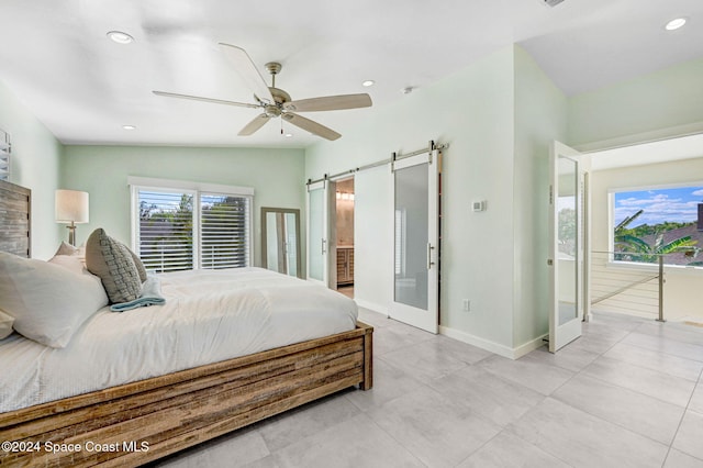 bedroom featuring french doors, vaulted ceiling, ceiling fan, a barn door, and connected bathroom