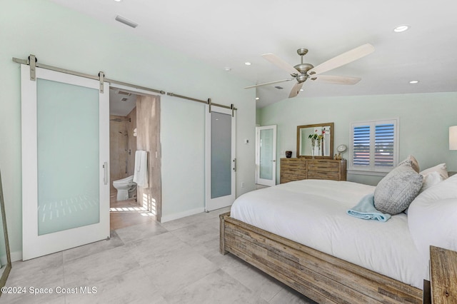 bedroom with connected bathroom, a barn door, ceiling fan, and lofted ceiling