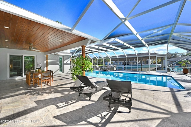 view of pool featuring a patio area, ceiling fan, and a lanai