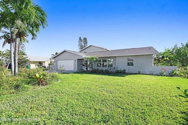 379 Hiawatha Way, Melbourne Beach, FL 32951 - back of property with an attached garage, stucco siding, and a lawn
