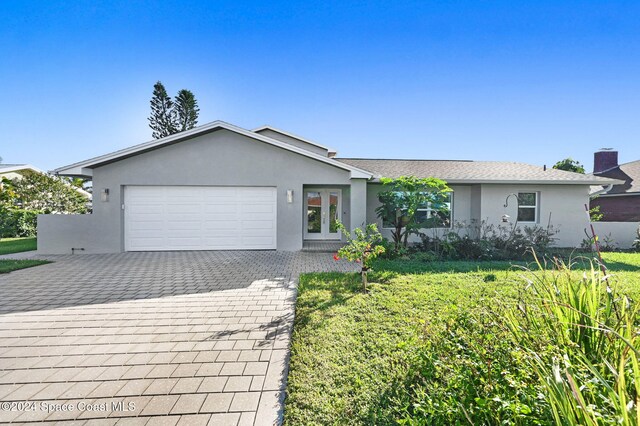 379 Hiawatha Way, Melbourne Beach, FL 32951 - ranch-style house with stucco siding, an attached garage, decorative driveway, and a front yard