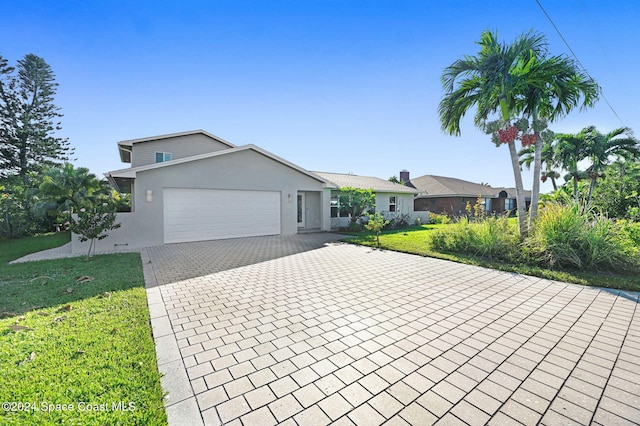 ranch-style home featuring a garage and a front lawn