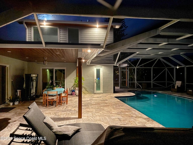 379 Hiawatha Way, Melbourne Beach, FL 32951 - pool at night with a patio area, an outdoor pool, and glass enclosure