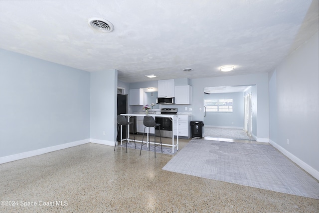 kitchen with a breakfast bar, white cabinetry, and stainless steel appliances