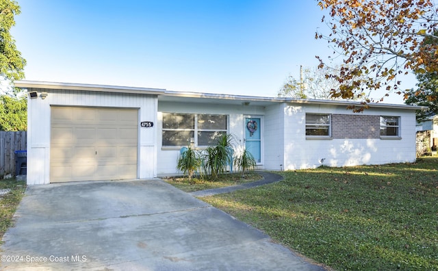 ranch-style house featuring a garage and a front lawn