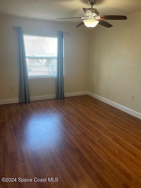 spare room featuring ceiling fan and dark hardwood / wood-style floors