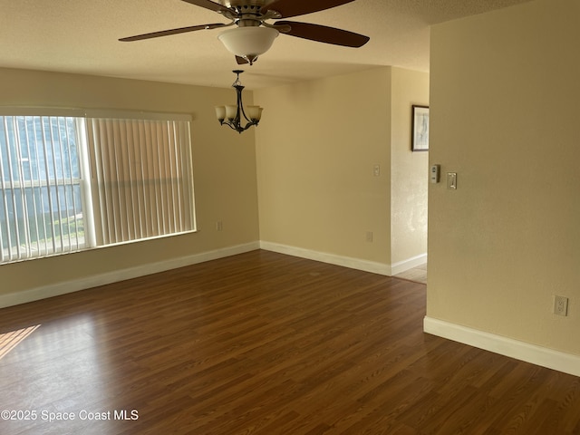 empty room featuring dark hardwood / wood-style floors and ceiling fan with notable chandelier