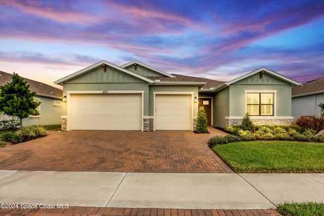 craftsman inspired home with a lawn and a garage