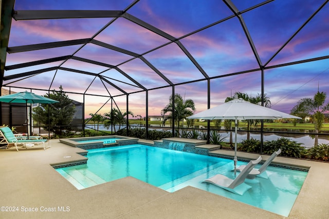 pool at dusk featuring an in ground hot tub, a water view, a patio area, and a lanai