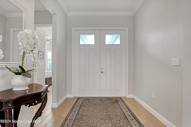 entryway featuring crown molding and light hardwood / wood-style floors